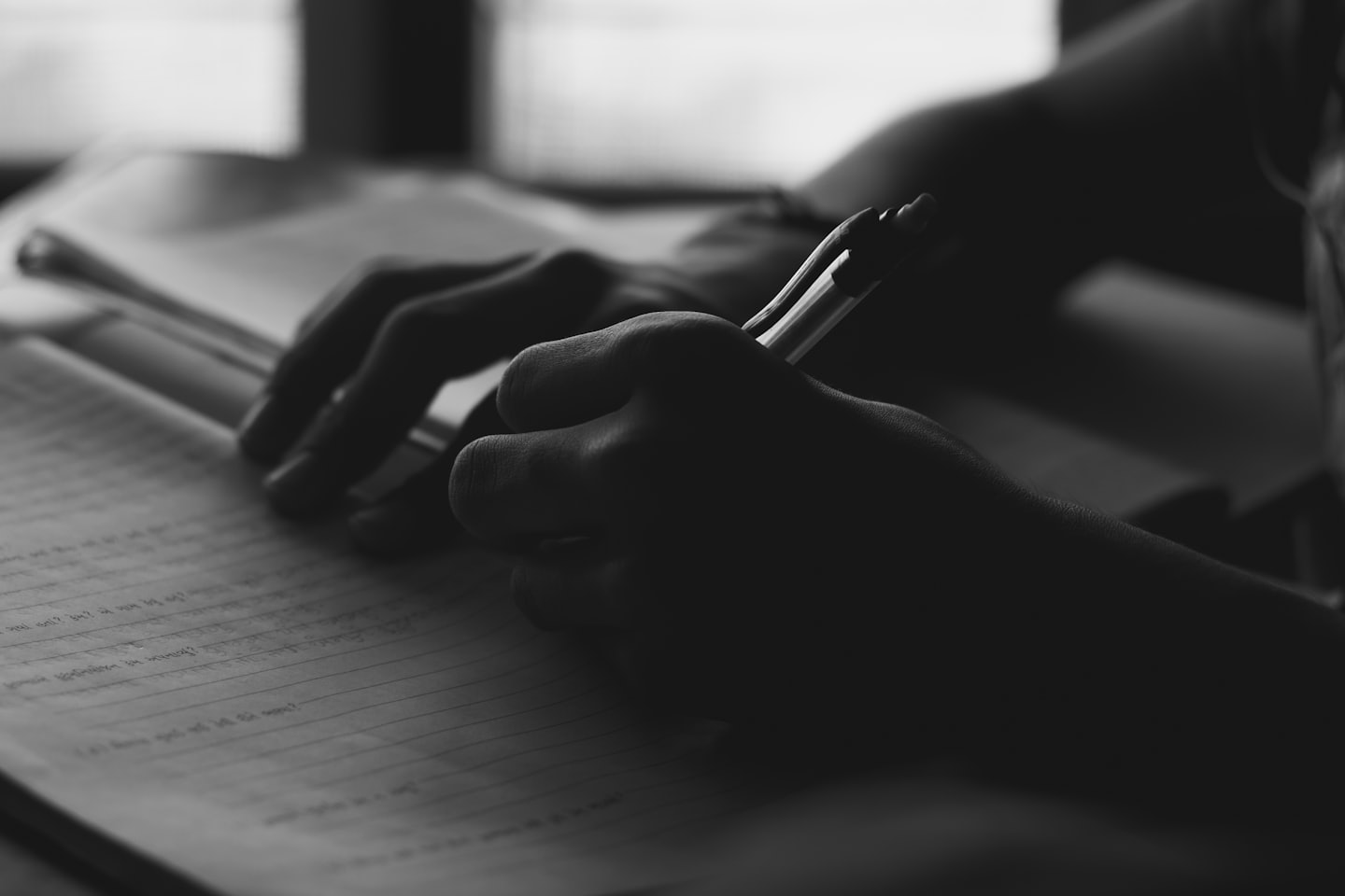 Black and white picture of a person writing with a pen